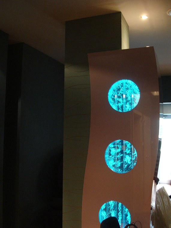 Kolumna w spa hotelowym, widok do akwarium w środku przez wyfrezowane dziury