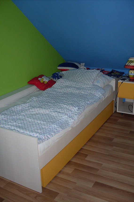 Pokój dziecięcy łóżko w kącie, pod łóżkiem szuflada wysuwana na pościel